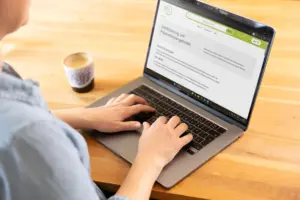 Frau arbeitet am Laptop an der Zertifizierung ihres Präventionsangebots bei Zertovia