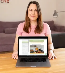 Eine Frau die an einem Tisch sitzt und einen Laptop präsentiert mit einem Präventionskurs